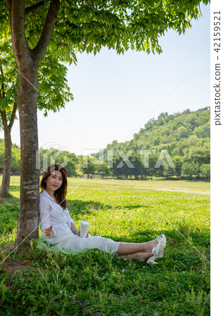 休息在樹的樹蔭下的婦女 42159521
