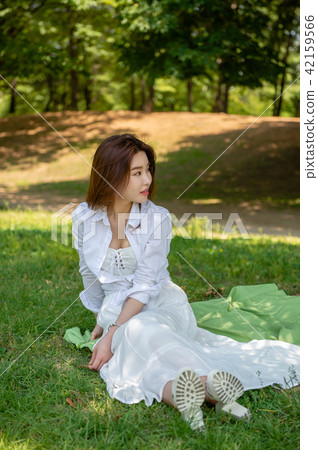 Woman resting in the shade of a tree Woman resting in the shade of a tree 42159566