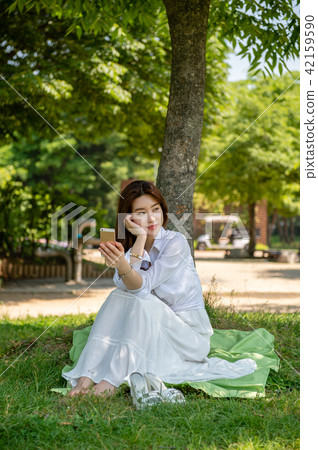 Woman resting in the shade of a tree 42159590