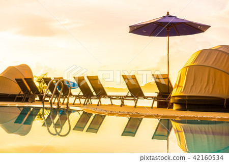 Beautiful outdoor view with umbrella and chair around swimming pool in luxury hotel and resort 42160534