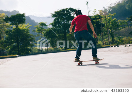Skateboarder sakteboarding on parking lot Skateboarder sakteboarding on parking lot 42163390