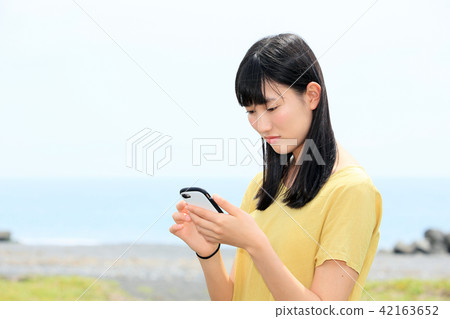 A young woman searching the net with a smartphone 42163652