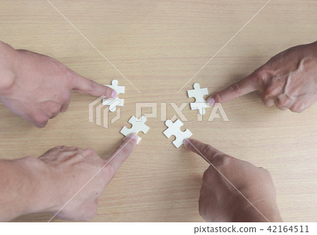 Group of business people assembling jigsaw puzzle Group of business people assembling jigsaw puzzle 42164511