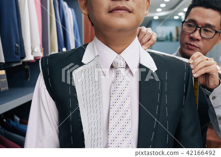 Tailor taking measurements 42166492