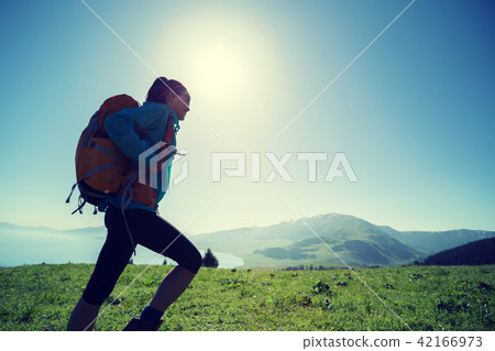 hiker walking on beautiful green mountain hill top hiker walking on beautiful green mountain hill top 42166973