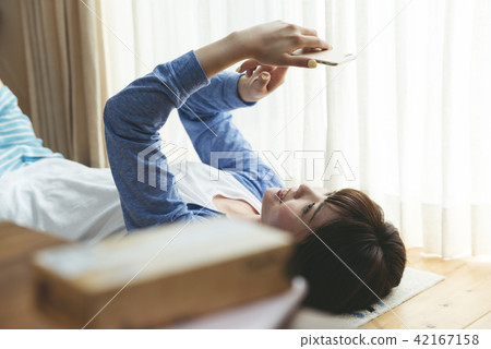 A woman touching a smartphone while sleeping 42167158