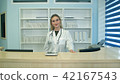 Smiling female doctor at the reception looking at the camera 42167543