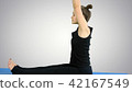Young woman stretching leg on mat, practicing yoga on white background 42167549