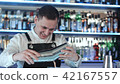Expert barman is making cocktail at night club 42167557