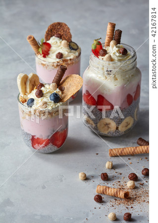 Chia pudding with yoghurt, honey, strawberry and banana on pastel concrete background Chia pudding with yoghurt, honey, strawberry and banana on pastel concrete background 42167814