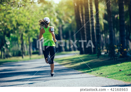 young fitness woman running at tropical park 42168983