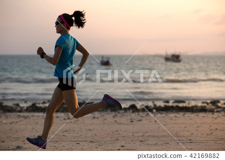 young fitness female runner running at beach young fitness female runner running at beach 42169882