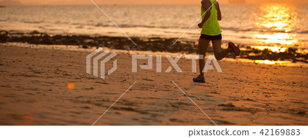 Young woman running at sunset sandy beach 42169883