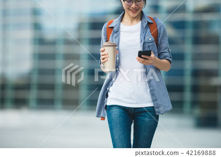 use mobile phone walking with coffee cup in hand use mobile phone walking with coffee cup in hand 42169888