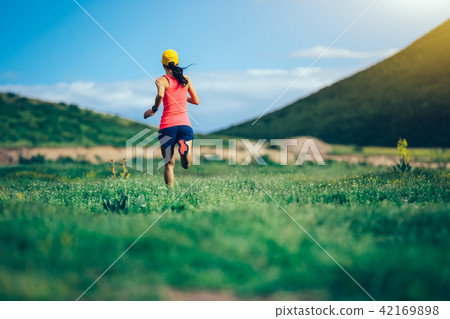fitness woman trail runner running in mountains 42169898