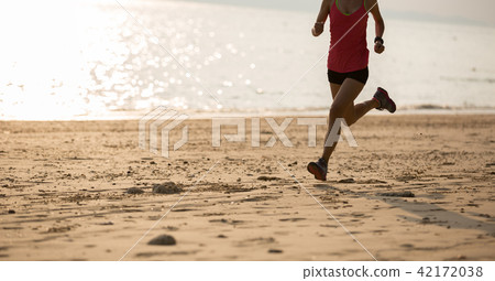 young fitness female runner running at beach young fitness female runner running at beach 42172038