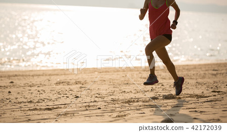 young fitness female runner running at beach 42172039