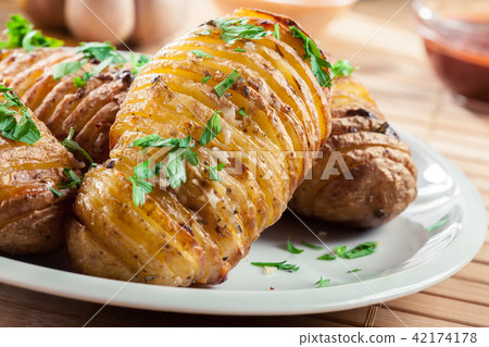 Baked potatoes with cheese and herbs Baked potatoes with cheese and herbs 42174178