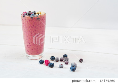 Glass of pink fruit smoothies milkshake or smoothie or cocktail on a white wooden background 42175860