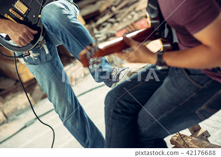 Repetition of rock music band. Electric guitar player and drummer behind the drum set. Repetition of rock music band. Electric guitar player and drummer behind the drum set. 42176688