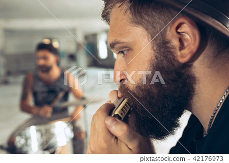 Repetition of rock music band. man with harmonica and drummer behind the drum set. Repetition of rock music band. man with harmonica and drummer behind the drum set. 42176973