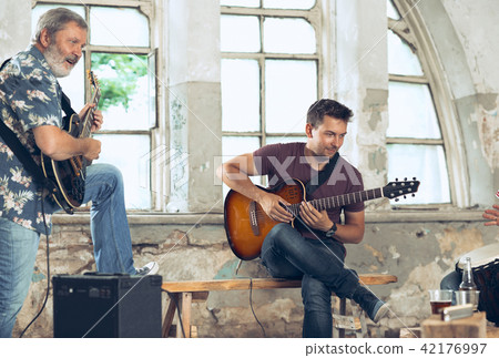 Repetition of rock music band. Electric guitar player and drummer behind the drum set. Repetition of rock music band. Electric guitar player and drummer behind the drum set. 42176997