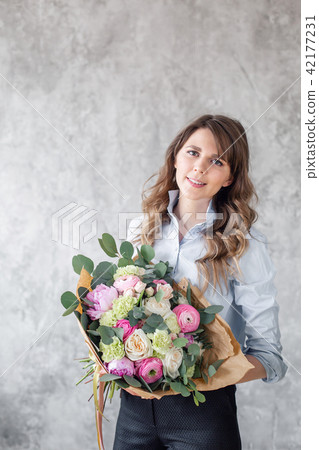 Young Woman looking at the camera, holds a luxurious bouquet in his hands. florist creating Young Woman looking at the camera, holds a luxurious bouquet in his hands. florist creating 42177231