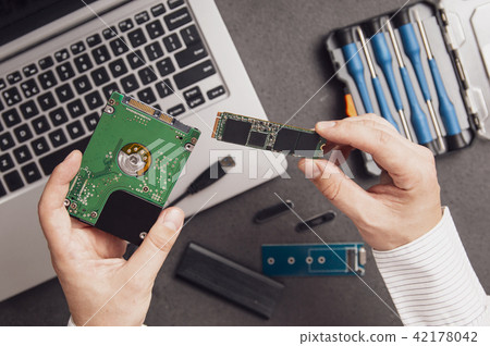 Man prepares to replace an old HDD drive Man prepares to replace an old HDD drive 42178042