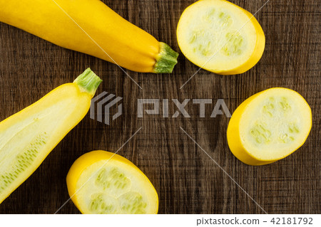 Fresh Raw yellow zucchini on brown wood Fresh Raw yellow zucchini on brown wood 42181792