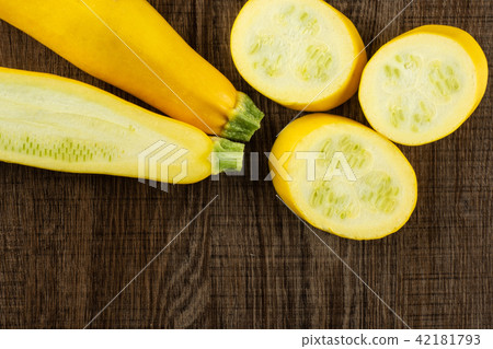 Fresh Raw yellow zucchini on brown wood Fresh Raw yellow zucchini on brown wood 42181793