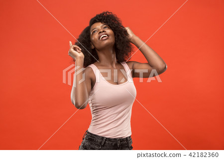 The happy african woman standing and smiling against red background. The happy african woman standing and smiling against red background. 42182360
