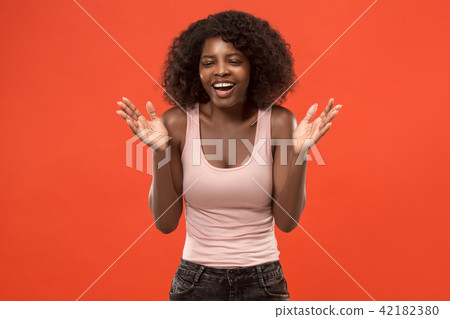 The happy african woman standing and smiling against red background. The happy african woman standing and smiling against red background. 42182380