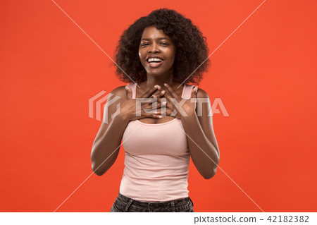The happy african woman standing and smiling against red background. The happy african woman standing and smiling against red background. 42182382