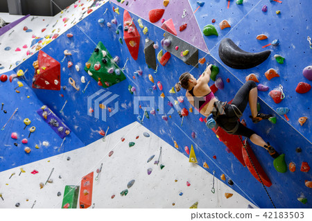 Photo of sports woman from back with bag for talc climbing on wall Photo of sports woman from back with bag for talc climbing on wall 42183503