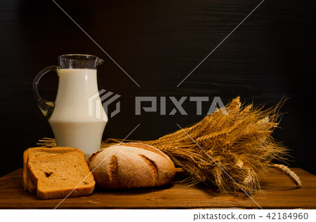 Wooden table with a jug of milk, rye bread Wooden table with a jug of milk, rye bread 42184960