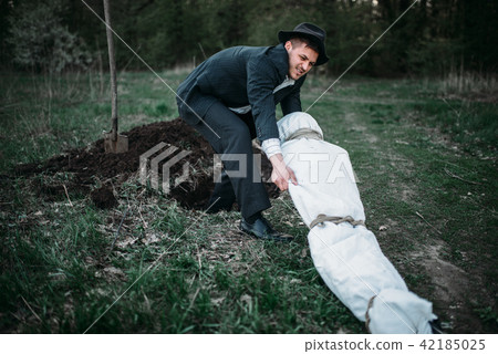 Maniac with victim's body wrapped in a canvas 42185025