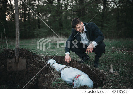 Maniac against grave, serial murderer concept 42185094