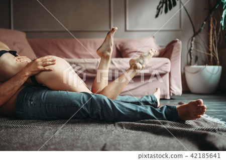 Playful couple hugs on the floor, erotica 42185641