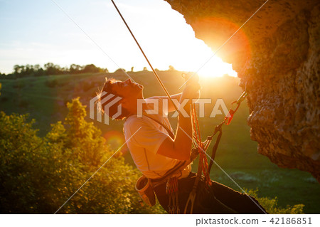 Picture of man clambering over rock. Picture of man clambering over rock. 42186851