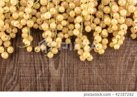 Fresh white currant berries on brown wood Fresh white currant berries on brown wood 42187282