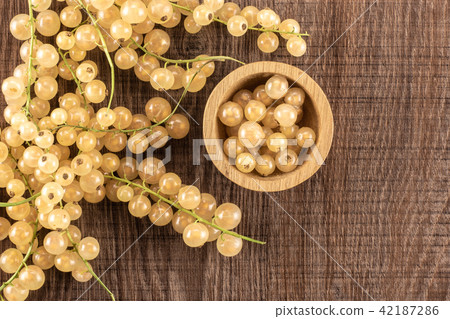 Fresh white currant berries on brown wood Fresh white currant berries on brown wood 42187286