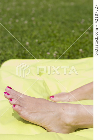 Feet of woman with nails painted red Feet of woman with nails painted red 42187527