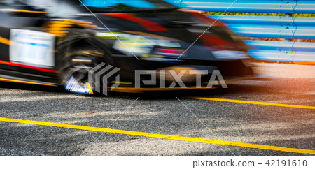 Motor sport car racing on asphalt road with fence 42191610