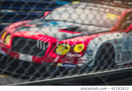 Blurred fence and racing car on racetrack  42191612