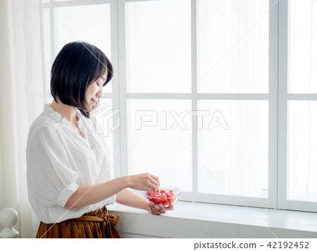 Woman having breakfast on window 42192452