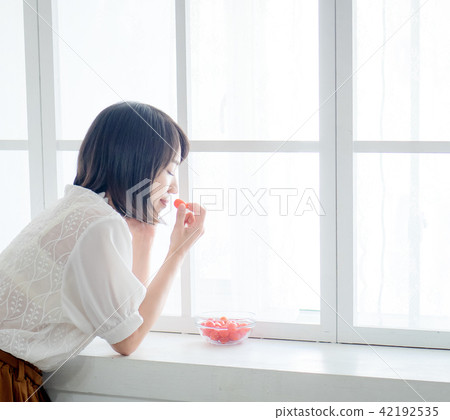Woman having breakfast on window 42192535