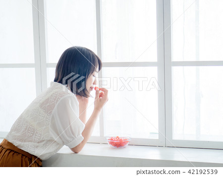 Woman having breakfast on window 42192539