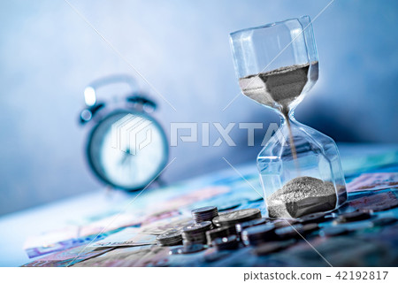 Hourglass and currency on table, Time Investment 42192817