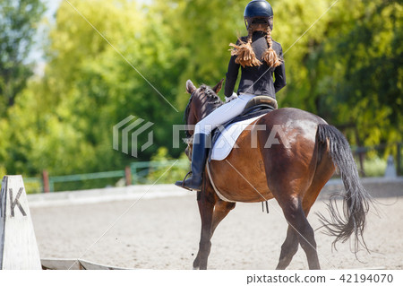 Young girl riding horse on equestrian competition 42194070