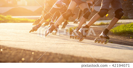 Group of teenagers skating on track in the evening Group of teenagers skating on track in the evening 42194071
